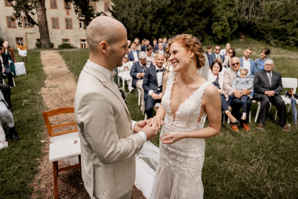 Leonie und Matthias lachen sich während ihrer freien Trauung im Schlossgut Lüll an.
