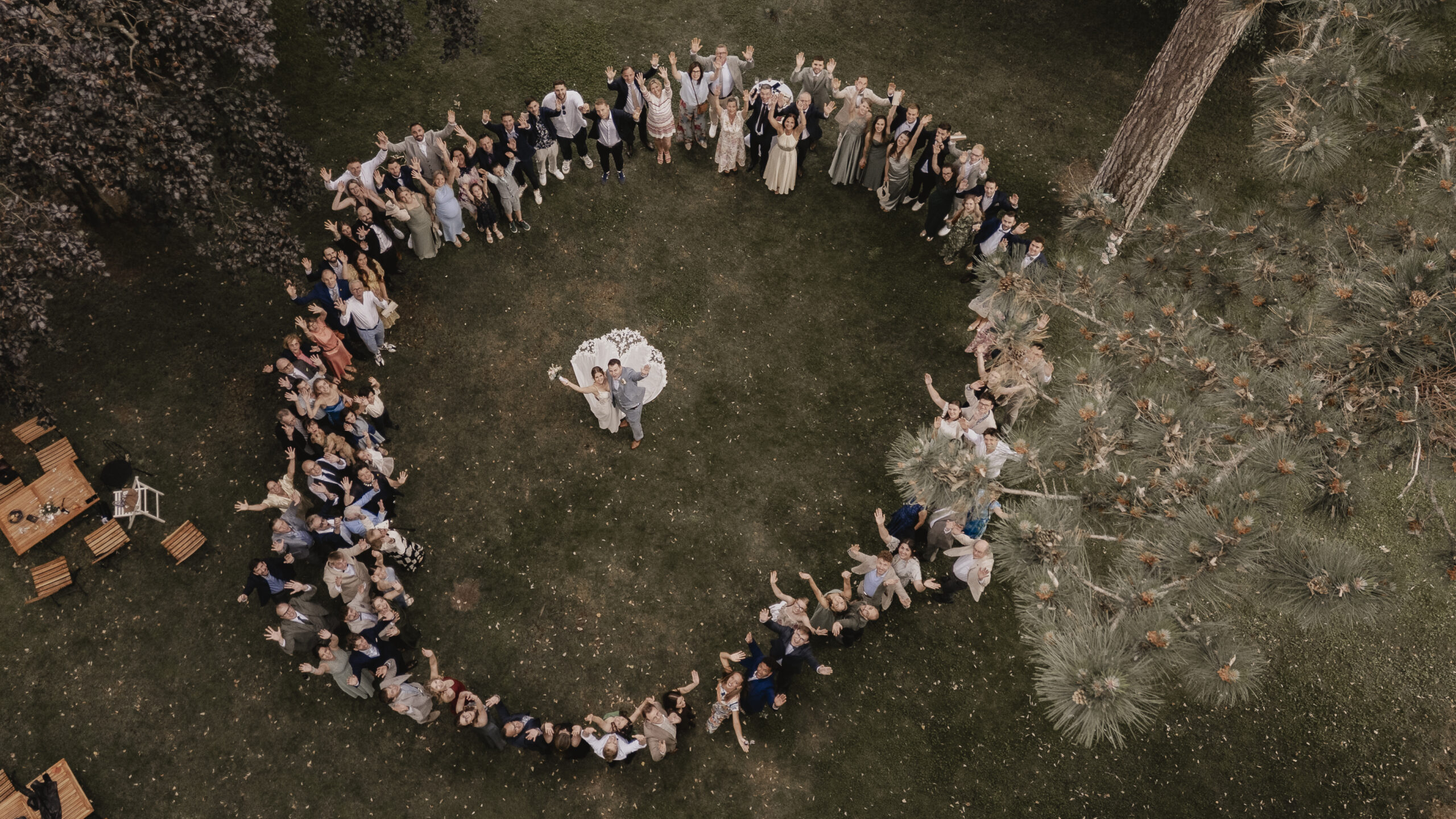 Luftaufnahme von Alexa und Michael inmitten eines Kreises ihrer Hochzeitsgäste